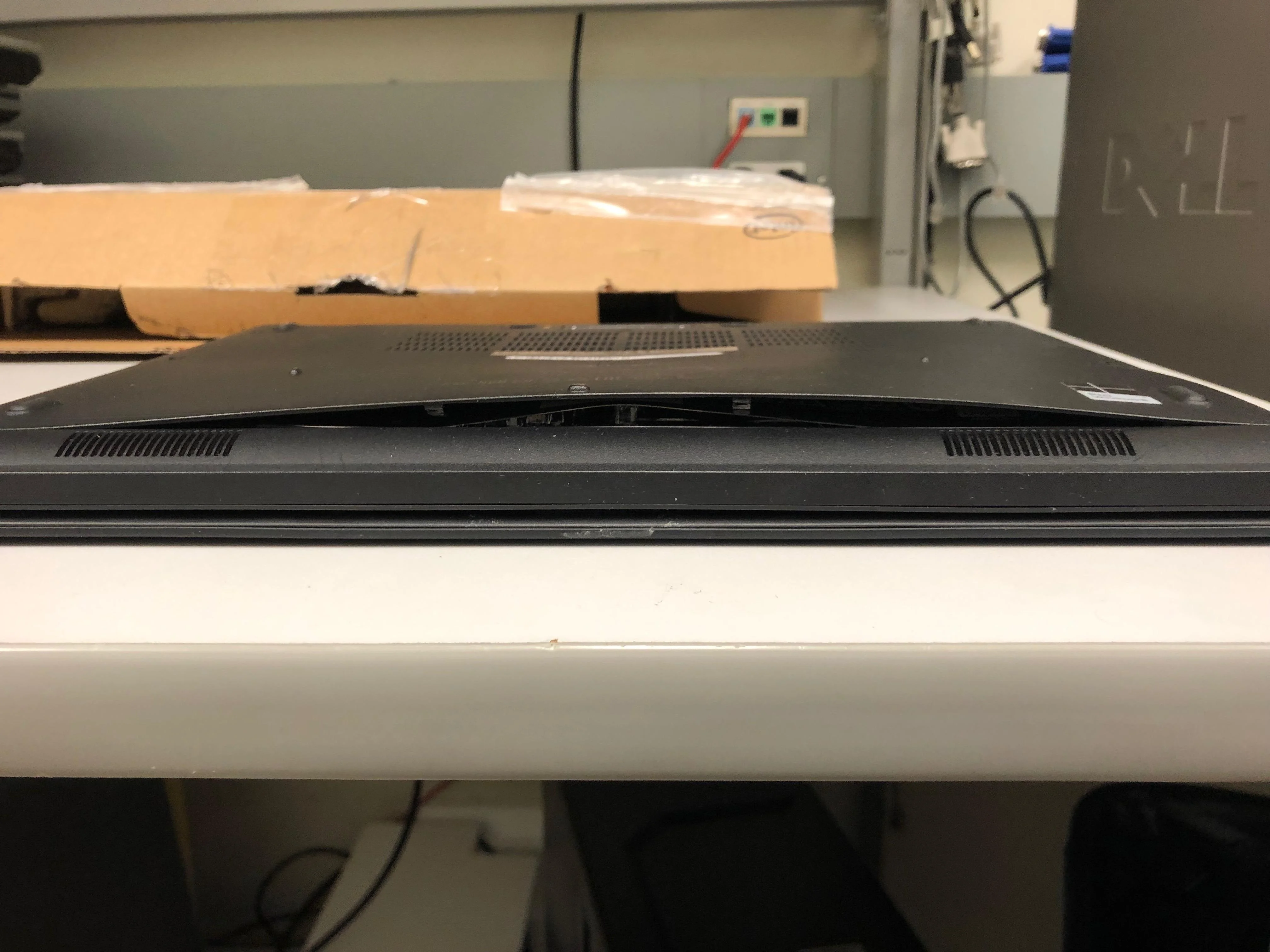an upside down laptop with the bottom of its case bulging