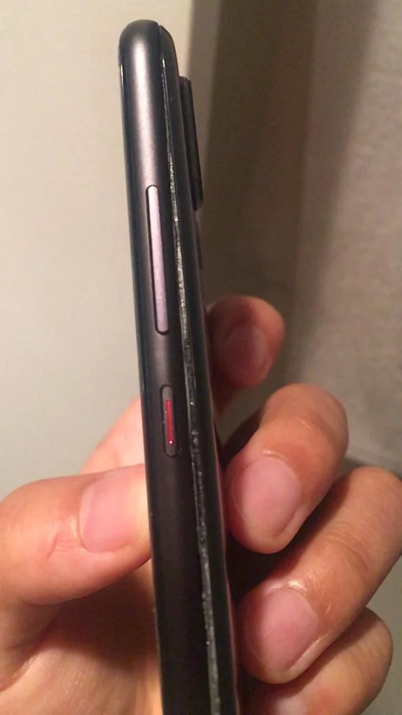 a side view of a phone where the back of the case is pushed out due to bulging