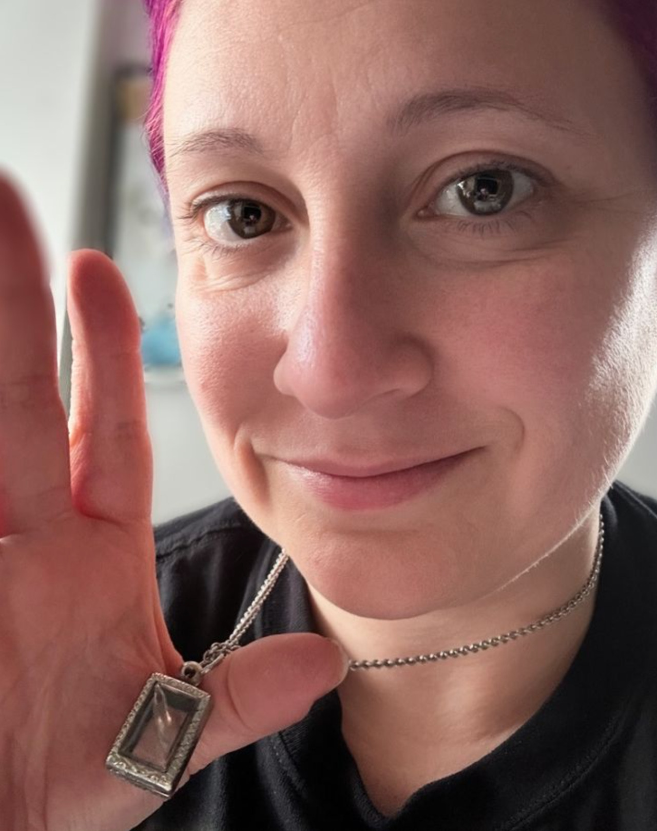 Picture of woman holding up a locket 