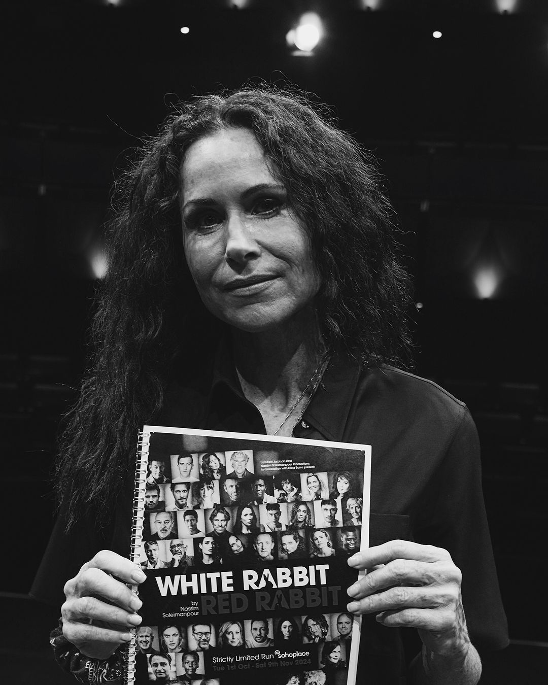 Picture of Minnie Driver holding up the White Rabbit Red Rabbit flyer. black and white photo