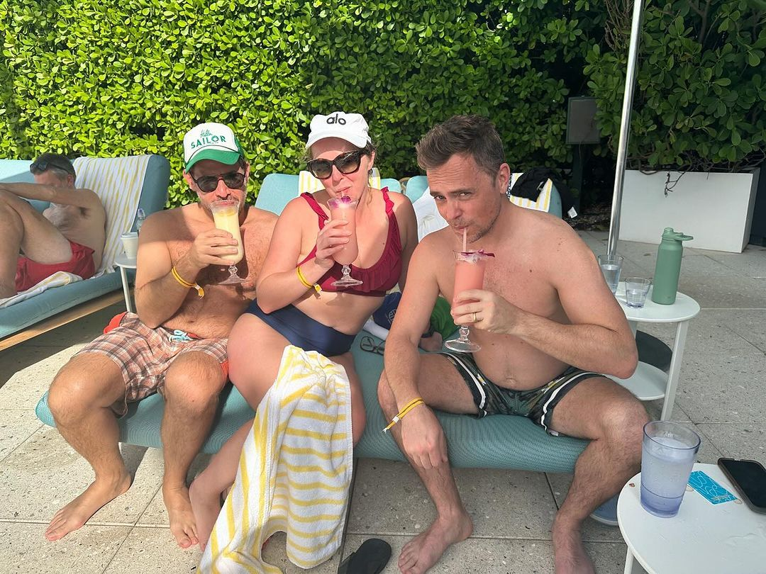 David sitting on beach chairs drinking alcohol with friends