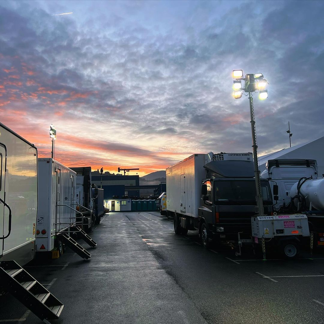 Photo of a studio lot with a number of cast/crew trailers and equipment trucks.