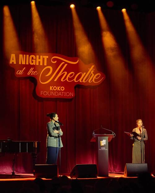 Minnie Driver and FKA Twigs on stage at the Koko Foundation event. They are standing a few metres apart with the podium between them, and Minnie is watching Twigs speak.