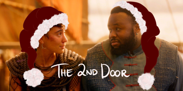 Image of the 2nd ‘door’ of the Advent Calendar. Jim and Oluwande are looking softly at each other in a scene from episode 3 of season 2 of Our Flag Means Death.  The image has been digitally altered – digital drawing has been added to make it look like they’re both wearing red velvet Santa hats.  In the middle, at the bottom of the photo, is the handwritten text: “The 2nd Door”.