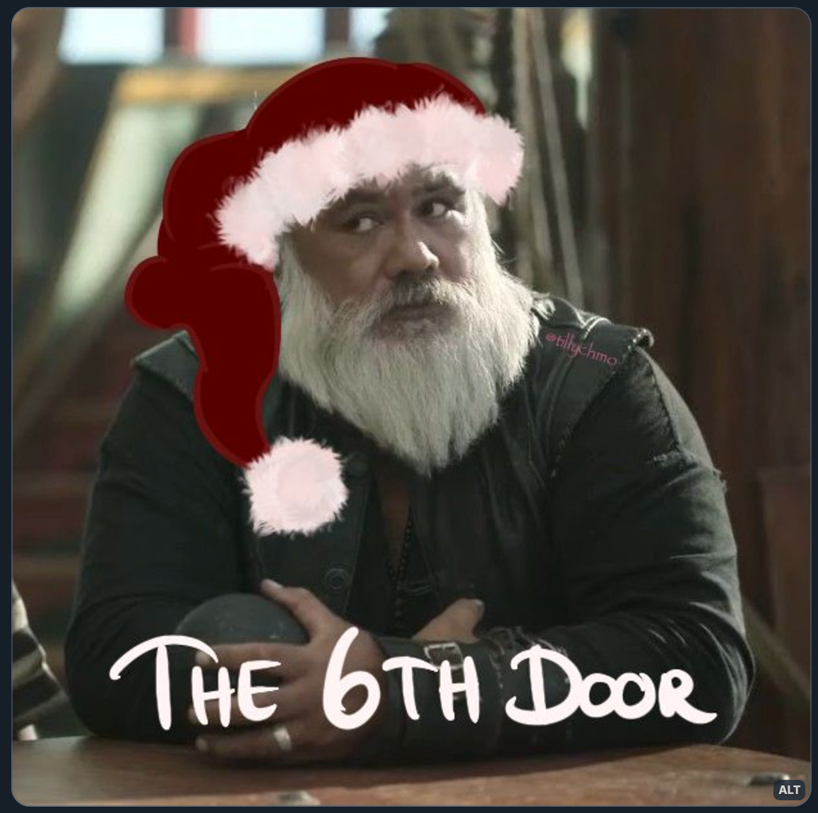 Digitally altered image of Fang (David Fane) from Our Flag Means Death (can’t remember the episode, but it’s from season 1). He is resting his hands atop the thing that hauls in the anchor, and side eyeing someone.  The still has been digitally altered by drawing a Santa hat on his head (making him look very much like Santa Claus 🎅🏻🙂‍↕️😅). Across the bottom of the image is handwritten text that reads: “THE 6TH DOOR”.  (Digital altering by: TillyChMo)