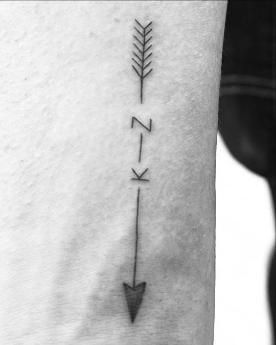 David's new tattoo, also shot in black & white. It is a minimalist design of an arrow broken up by the letters K and Z.