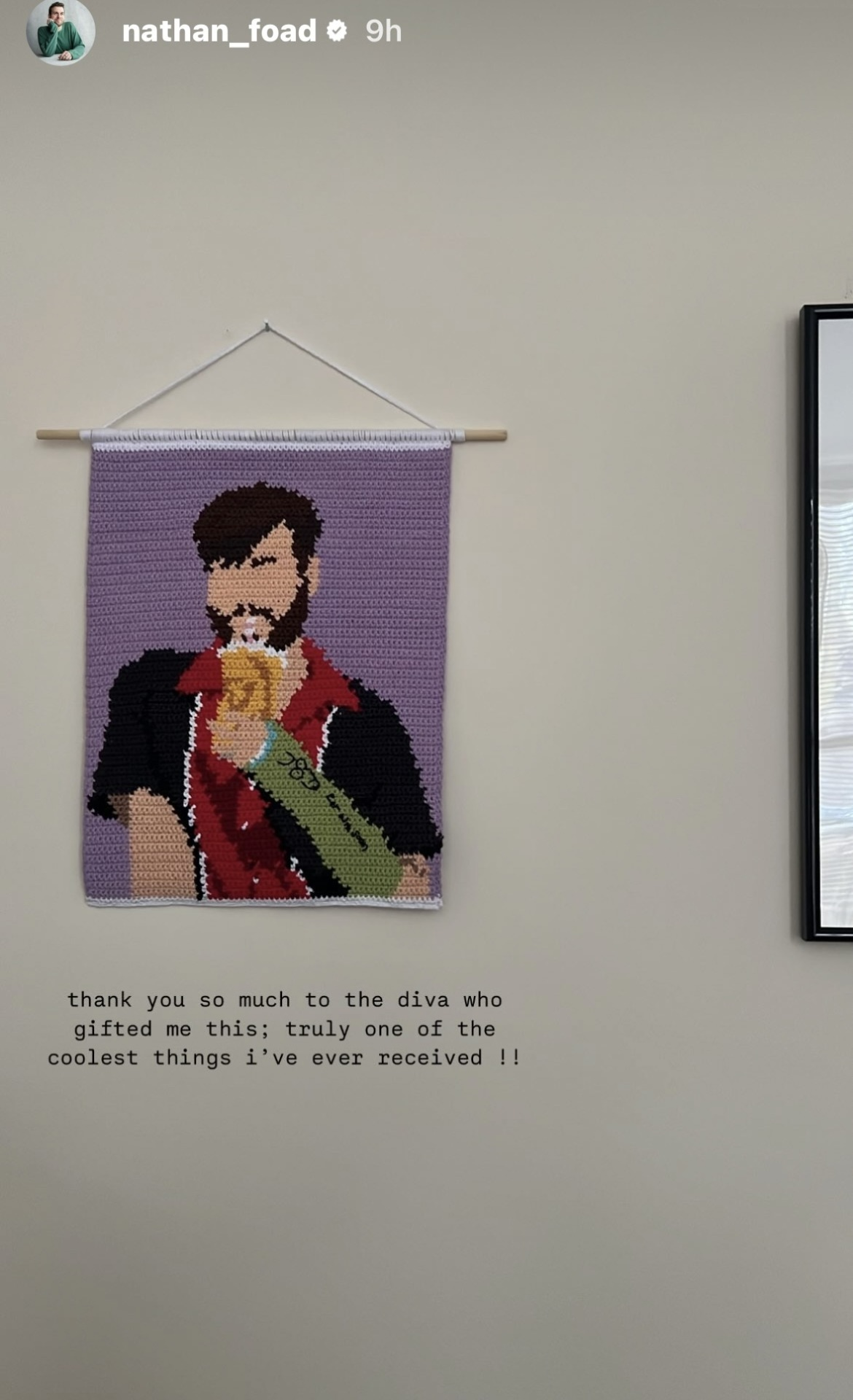 Instagram story by Nathan Foad: a photo of a small scroll tapestry hanging on a white wall. It also depicts his character Rowan from 'Newark, Newark', but in a minimalist style with no eyes or nose, on a purple background. Rowan is drinking from a takeaway cup with a straw, his arm in a green cast with a penis and some writing scribbled on it. Text at the bottom of the photo reads: thank you so much to the diva who gifted me this; truly one of the coolest things I've ever received!!