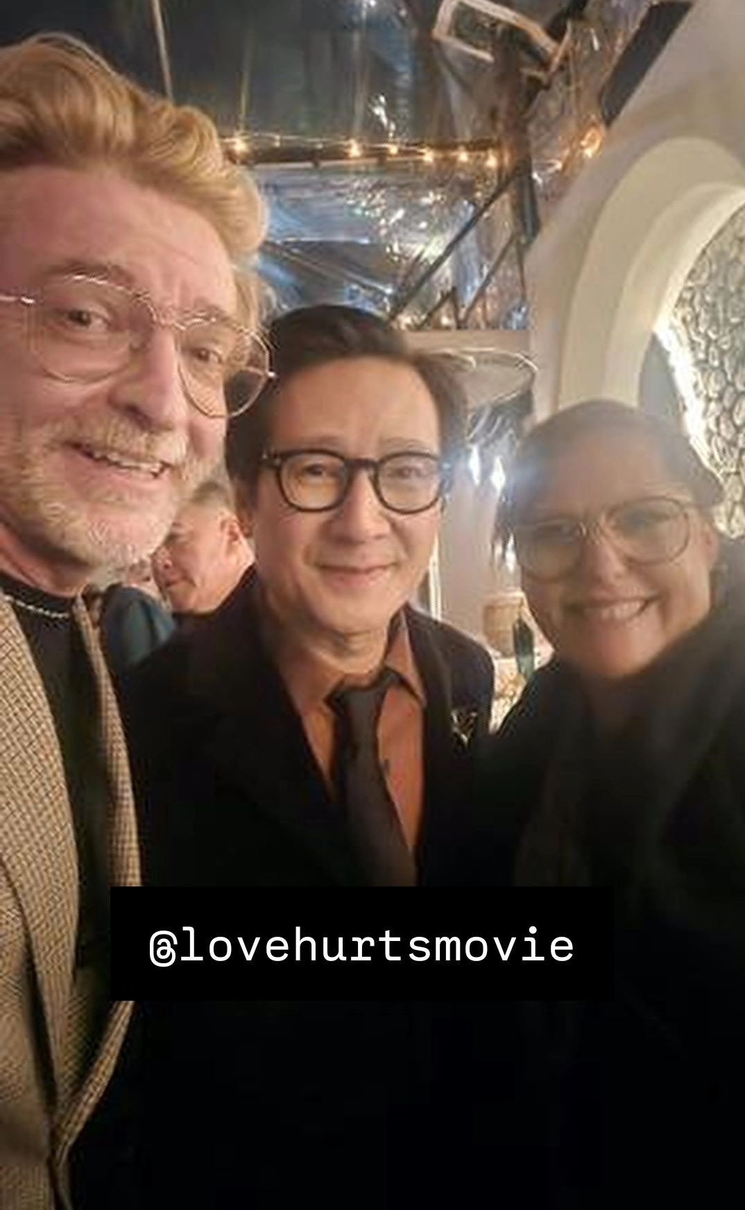 Selfie of Rhys Darby, Ke Huy Quan and Rosie Carnahan-Darby at the Love Hurts premiere, all 3 of them smiling broadly at the camera. @ LoveHurtsMovie is tagged at the bottom of the photo.