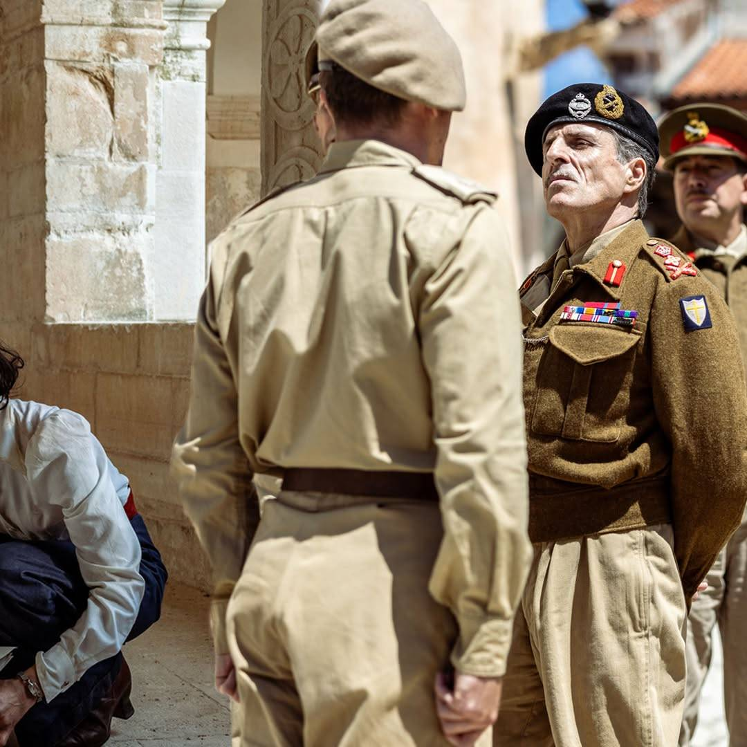 Production still from SAS Rogue Heroes showing Con O'Neill as General Montgomery looking critically at another soldier who is seen from behind, standing to attention.