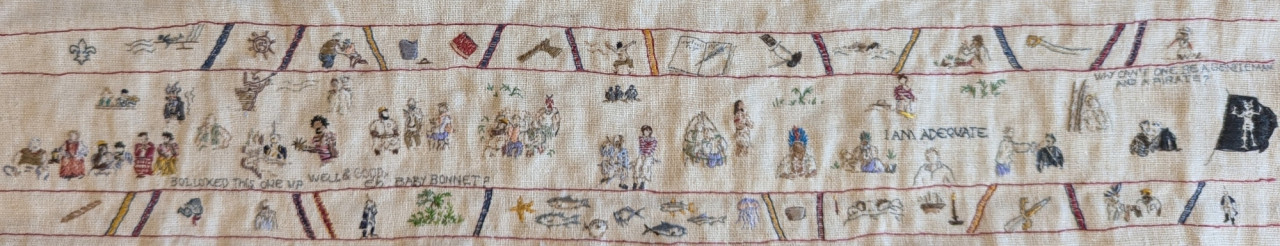 Image description by the artist: Small embroidery in the style of the Bayeux Tapestry. The central panel depicts episode 2 of the TV show Our Flag Means Death with smaller panels above & below featuring additional scenes and items from the episode.