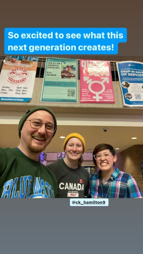 Selfie of Alex and 2 students inside a university building. The photo is taken from a low angle so we can see that they are standing below a mezzanine or walkway with several posters hanging on its railing. One poster features a photo of Alex next to the text ‘Join us for a cinematic experience with Alex Sherman’. The poster next to it is for a queer rave, with a large trans symbol printed on a pink background. Above the posters, Alex has added the text ‘So excited to see what this next generation creates!’ and below the photo, he has tagged the account @ CK_hamilton9 .