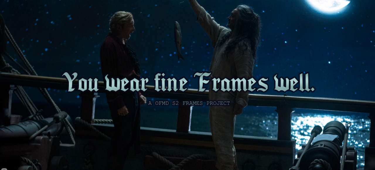 A still from the scene in Our Flag Means Death season 2 where Edward and Stede stand on the deck of the Revenge at night and Ed proudly shows Stede the fish he caught. The words 'You wear fine frames well. An OFMD frames project' are written across the center of the image.