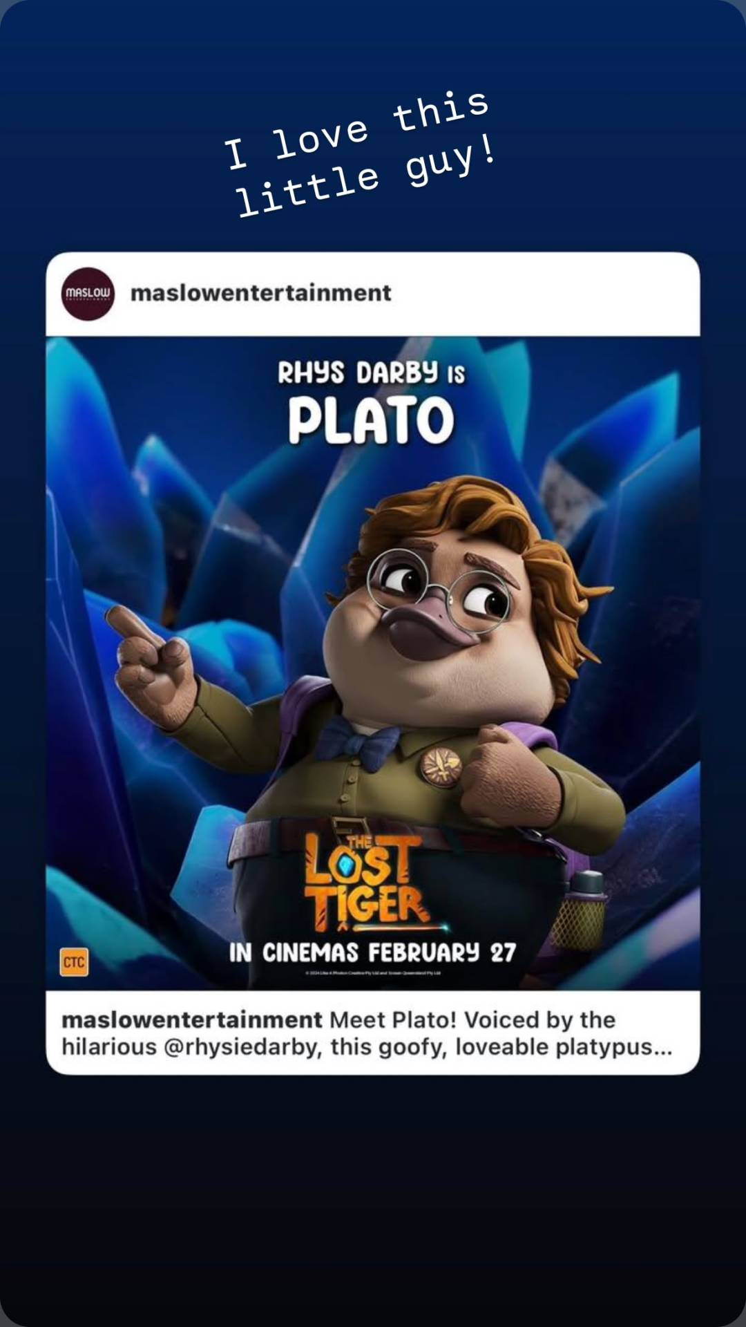 Rhys's Instagram Story where he shared a post from @ MaslowEntertainment: a picture of an anthropomorphic platypus with blond hair, wearing round wire-frame glasses, a green button-up shirt with a blue bow-tie and a purple backpack. Text at the top reads 'Rhys Darby is Plato', and at the bottom: 'The Lost Tiger, in cinemas February 27'. Above the shared post, Rhys has added: 'I love this little guy!'